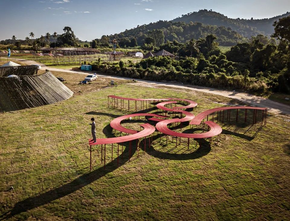 「The Walk」是抬高於草地之上的人行步道，出現在曼谷的「Wonderfriut Festival」節慶活動，試圖喚起人們對草地與植栽的關愛、瞭解其重要性，並重新認識日常生活中容易忽略的細部。景觀喚醒了人們的環保精神，讓人注意到身邊的自然之美，思索慶典、環境、文化與藝術的豐富主題。