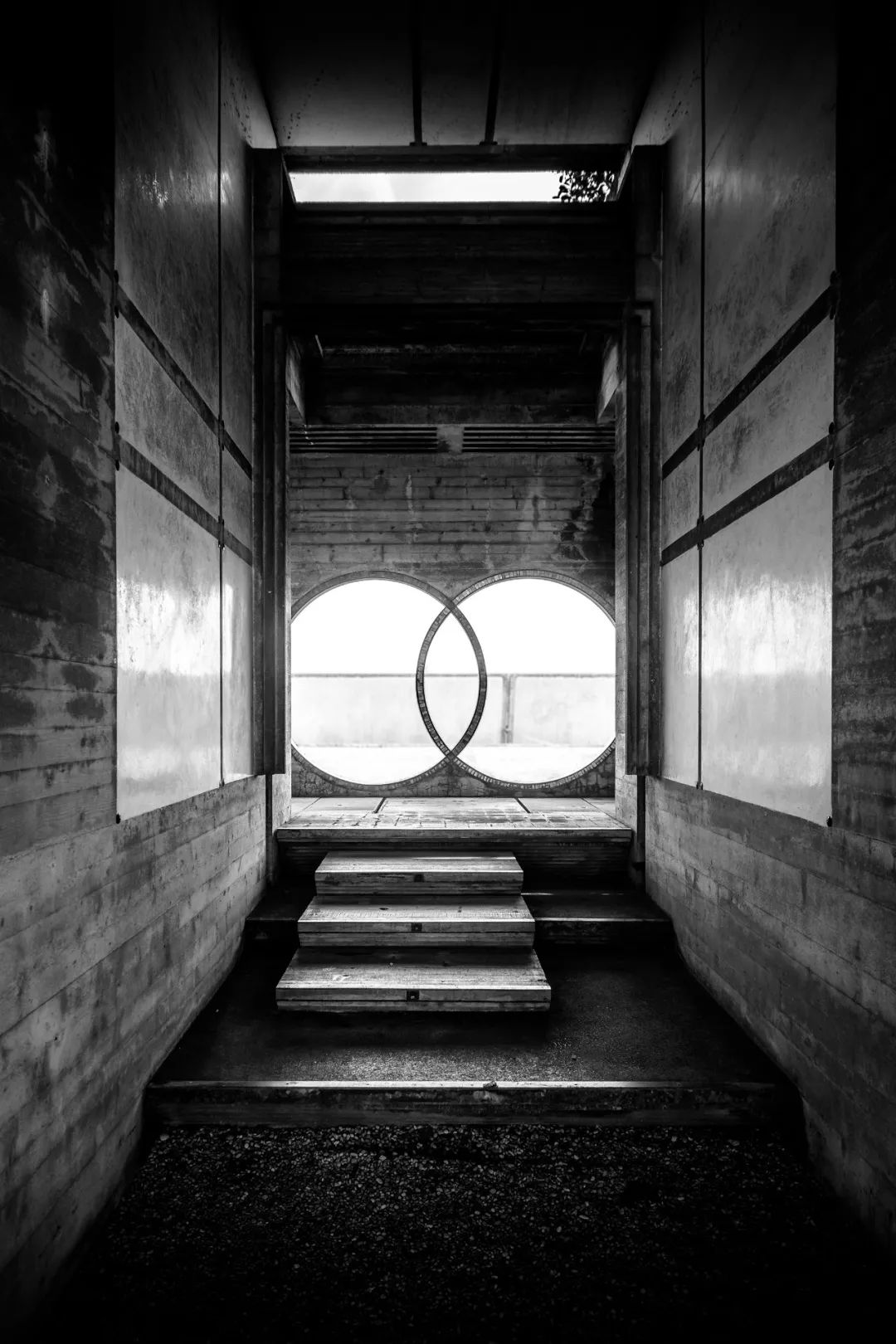 Tomba Brion 布里昂家族墓園 Brion-Vega Cemetery／Carlo Scarpa 露出水面的混凝土牆已經風化，斑駁的牆面與青綠的苔蘚是時間留下的生命印跡。禮拜堂和布里昂夫婦的拱頂墓室在基地中被旋轉了45度，消隱了墓園內部的轉角邊界。低矮的圍牆也使整個墓園與外圍空曠的基地與村子進行著一場兩個次元空間的對話。