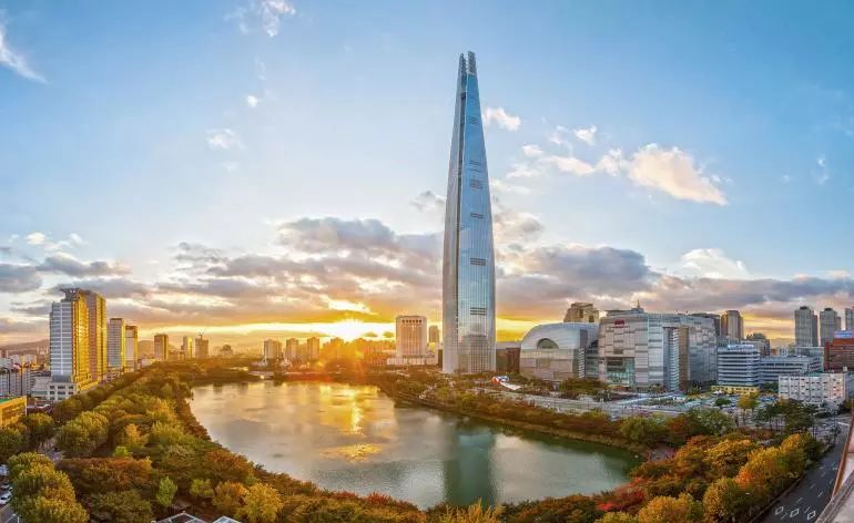 首爾，作為韓國的首都，近年來正積極地進行城市更新和建築改造的工程。為了迎接現代化的趨勢與國際標準，首爾不斷地推陳出新，打造出既具有韓國特色又展現現代風貌的建築。在這當中，樂天世界大廈無疑是其中的矚目之星。這座摩天大樓不僅是首爾市區的新地標，更是韓國都市建築的代表作之一。從遠方眺望，它高聳入雲，展現了首爾都市發展的活力和魄力。這張照片捕捉到了樂天世界大廈的宏偉與壯觀，完美地呈現了首爾這座都市的進步與蛻變