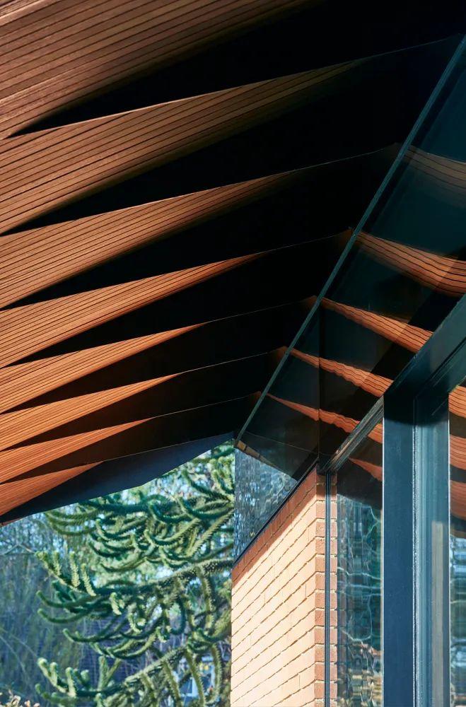 錐形的鋼構材由集成材（Glued-laminated timber, GLT）木構造延伸而出，在通風窗上方支撐著懸挑的屋簷