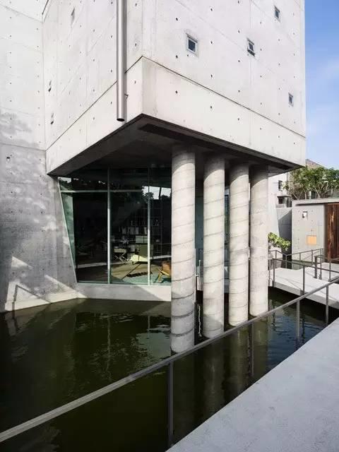 新造的金毛屋外部，用四根巨大的混凝土立柱支撐二層延展部分，同時將水景觀引入建築內部。 清水混凝土、清水模住宅 金毛屋／毛森江
