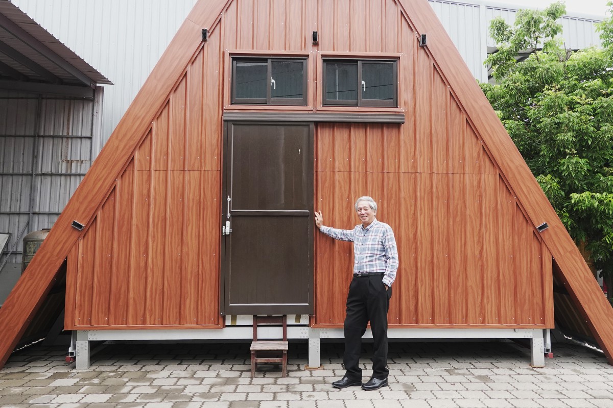 吳夏雄建築師與一手設計籌畫的山屋建築。圖/一路報導
