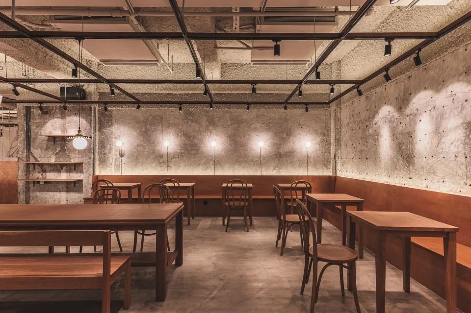 木傢俱與牆面地板的工業風形成趣味對比，上海Ufotable Café動漫主題餐廳咖啡館／Atelier A 