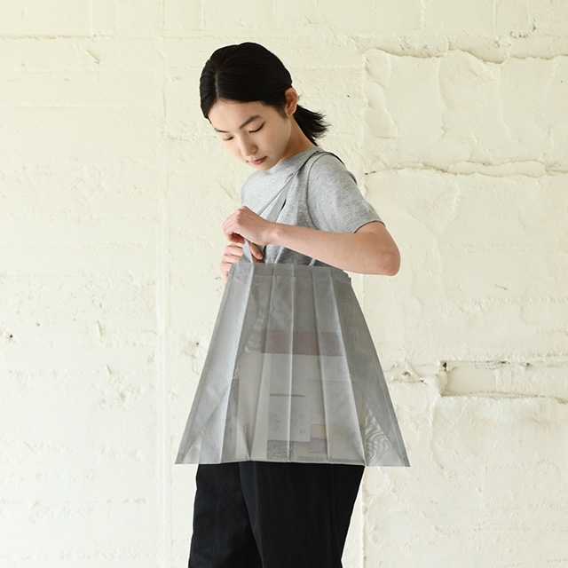 手提袋：使用建築光地常見的防碎網布，製作出有著寬大摺痕的手提袋，可以像摺紙一樣摺疊收納，便於攜帶。