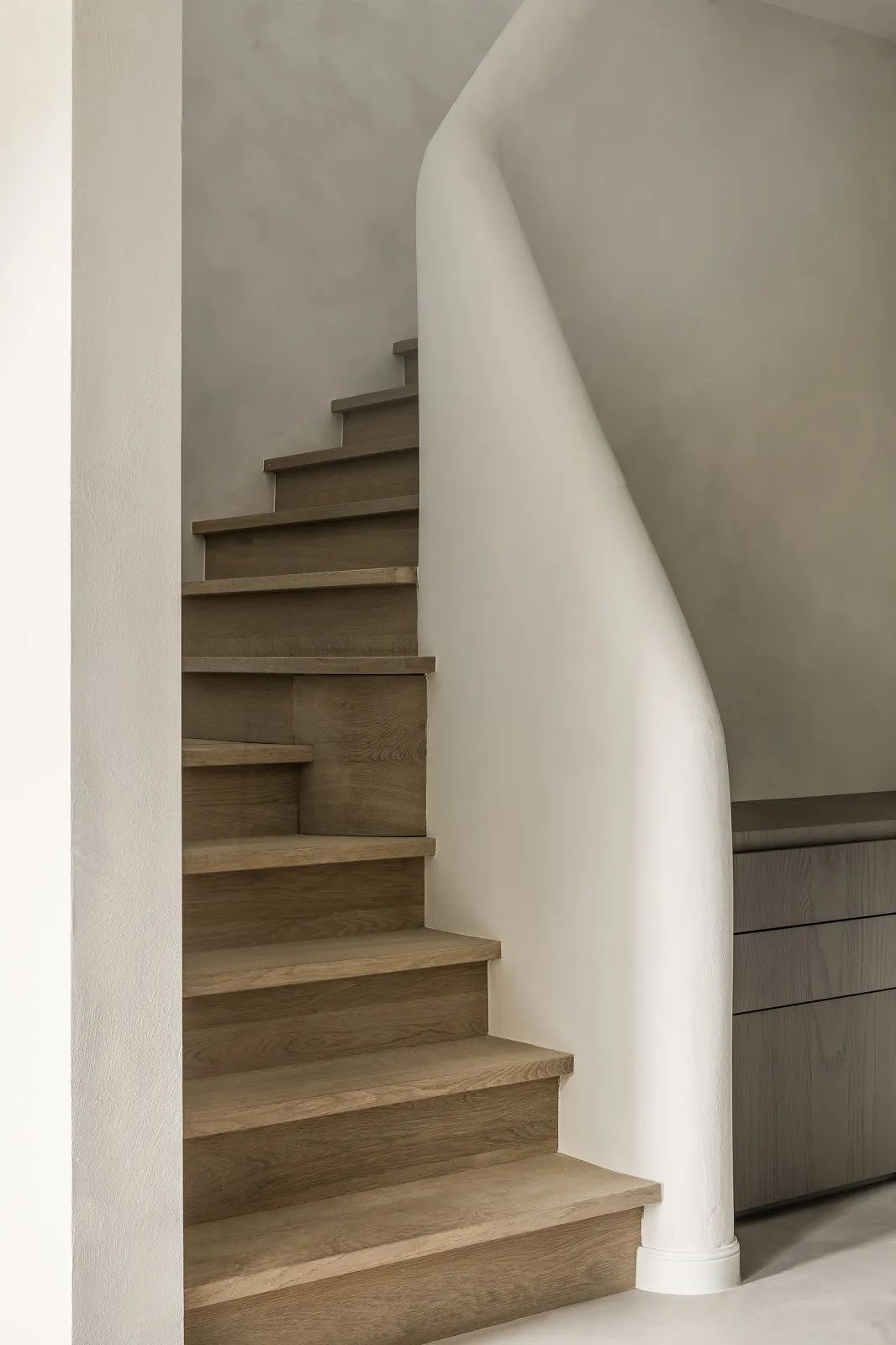住宅大樓梯間牆面結合天然的沙塗抹完成，原木的階梯與其共同呈現了設計師的極簡審美 比利時住宅Light Play/Marie Lecluyse