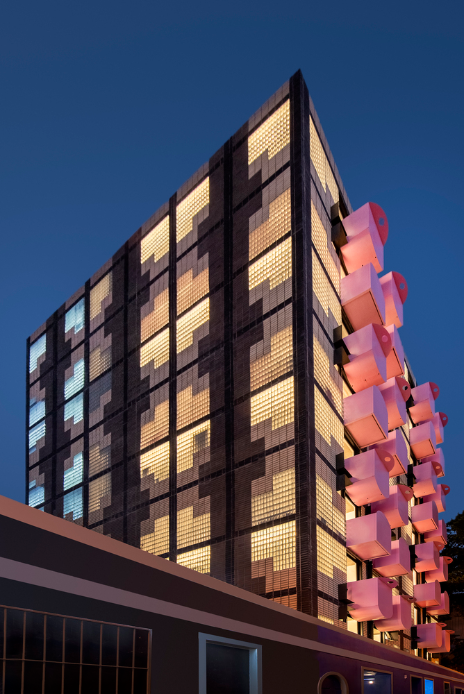 玻璃磚在夜間透出燈光，南非微型住所Uxolo Apartments／Two Five Five Architects