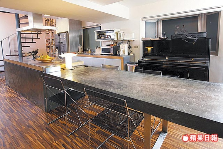 餐桌連結廚房吧台 流理台，空間開闊舒適，以水泥打造的餐桌表現出原始粗獷的美感。
