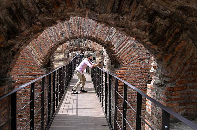 修復這些地下廊道的工程其實沒有想像中容易，因為在競技場漫長的歷史中，每位帝王都會根據自己的偏好來整修羅馬競技場，因此該如何修復它著實讓考古學家傷透腦筋。圖為一名在地下空間修復好後入場參觀的民眾。 歐新社/達志影像
