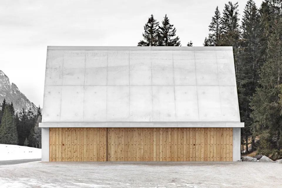 混凝土淡灰色的材質與木頭隔門，單純的色調融入在森林及雪地間 義大利世界自然遺產微建築公園服務設施Servicegebäude Kreuzbergpass／Pedevilla Architects