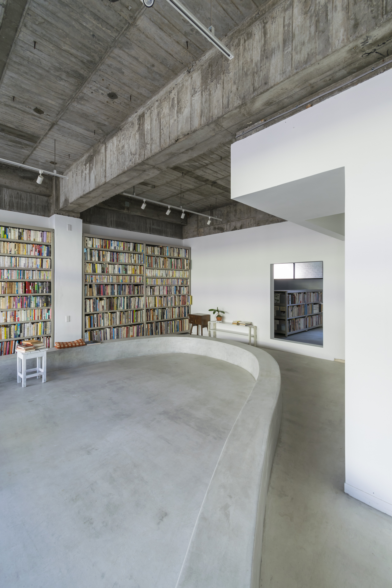 裸露的混凝土結構體、書架及座椅、白牆 日本鳥取市附帶小型圖書館的房子 租書店 Japan House／Hiroshi Kinoshita and Associates キノシタヒロシ建築設計事務所
