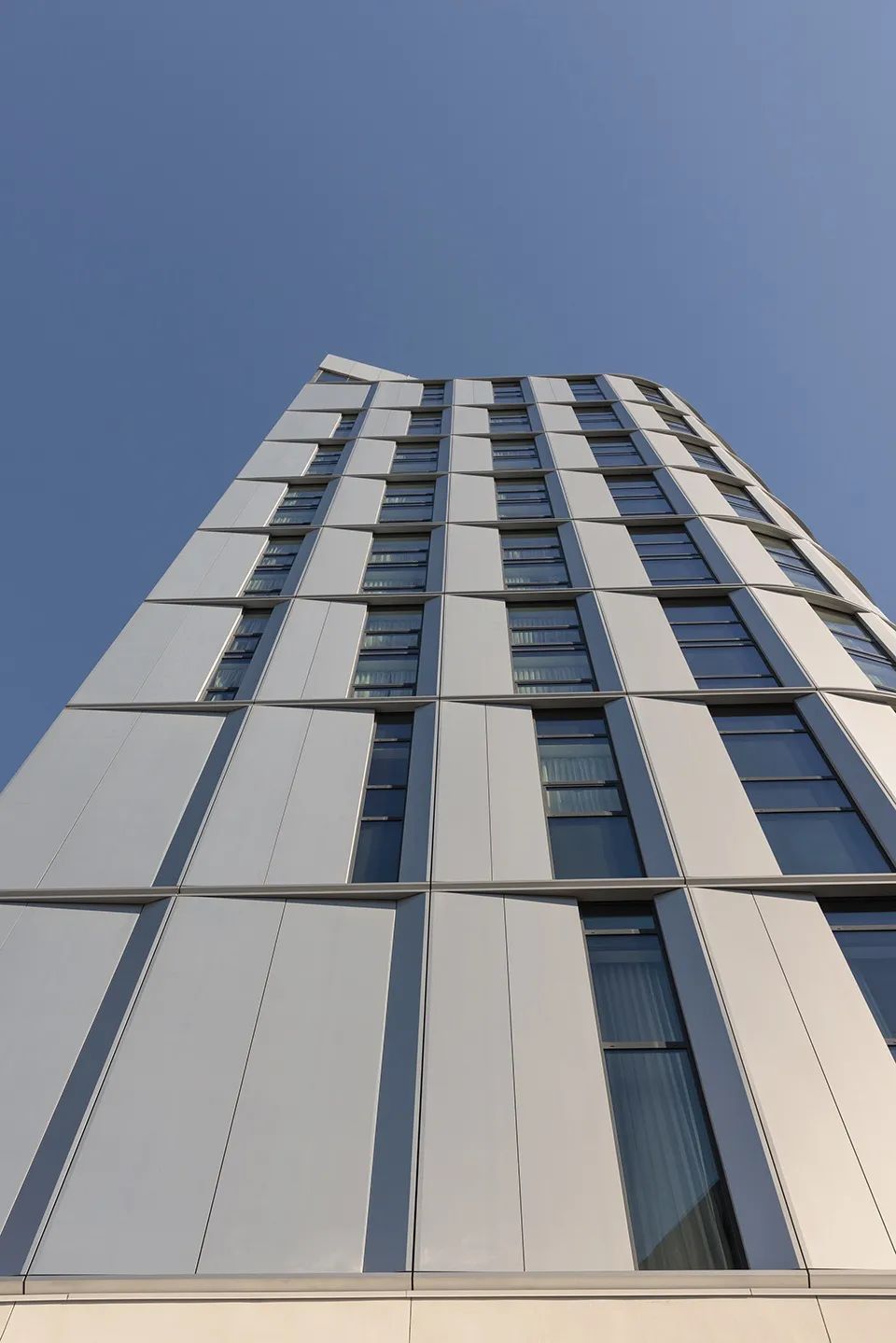 Graduate Hotels 柔緩的曲面被雙層高鋁製立面板包裹©Michael Grimm 康奈爾紐約市科技校區酒店和教育中心 Cornell Graduate Roosevelt Island Hotel+Verizon Executive Education Center/Snøhetta