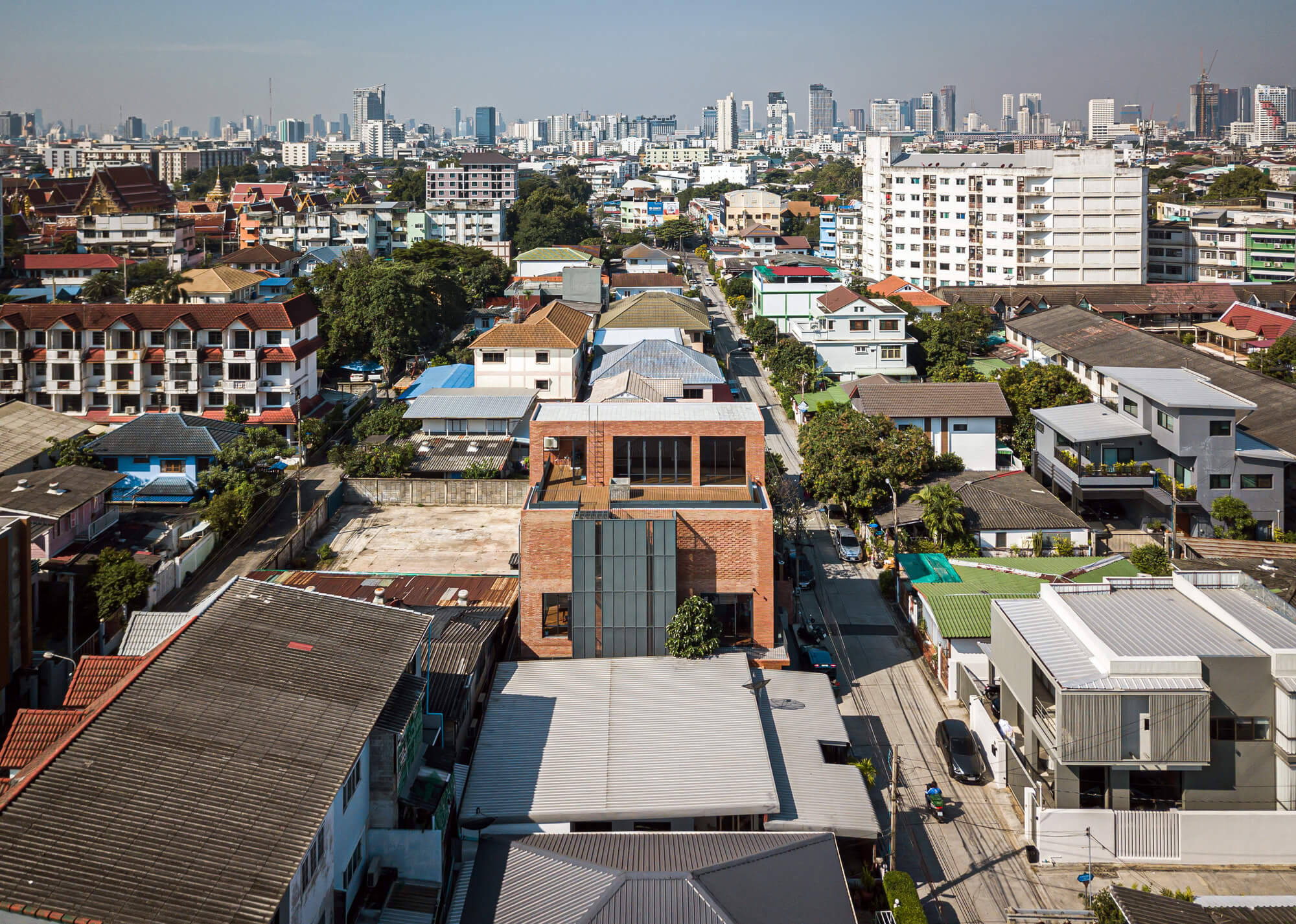 高磚屋坐落在曼谷市中心叻拋路（Lat Phrao）區，位於一塊被兩層樓房子和街屋包圍的都市環境中