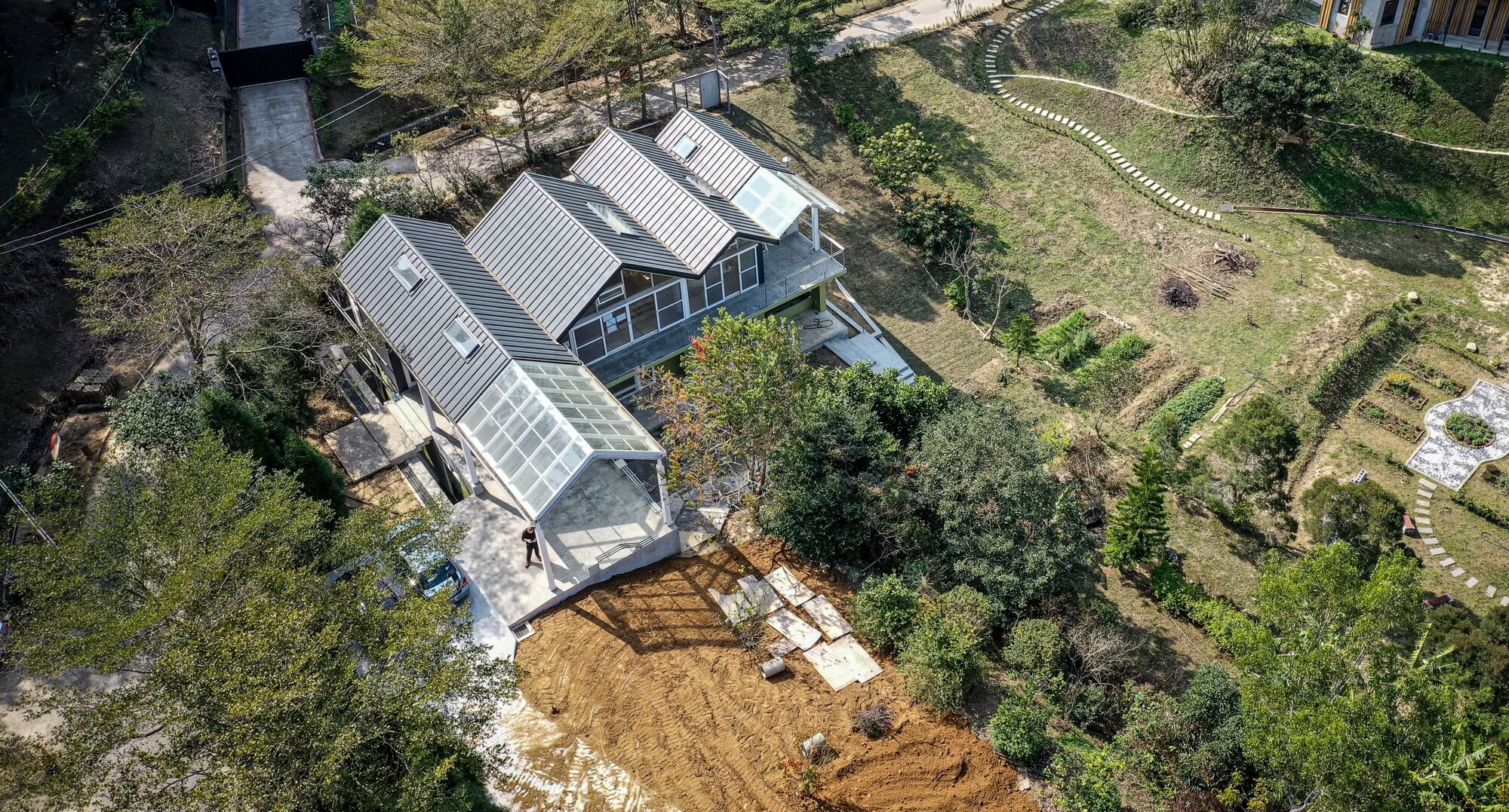 設計團隊藉由高低變化的山簷屋頂塑造家的意象,並將其作為人造地景融入自然地形
