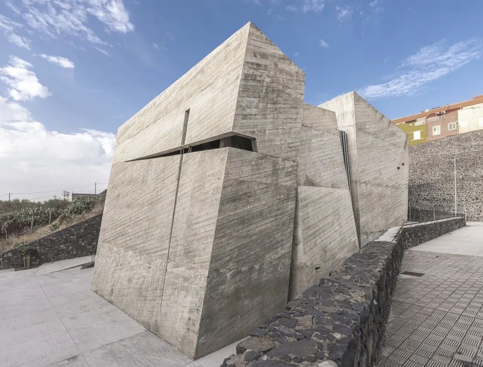 建築的靈感來自於加那利群島的火山地質，嵌入地面的巨大量體拔地而起，宛如四塊破土而出的巨石
