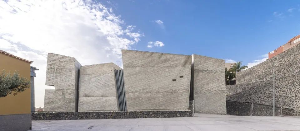 西班牙建築師 Fernando Menis 選擇以混凝土作為主要的建築材料,並藉由四個獨立量體,分別為教堂、社區中心及兩個戶外空間,以錯落有致的方式組合,營造出豐富的空間層次