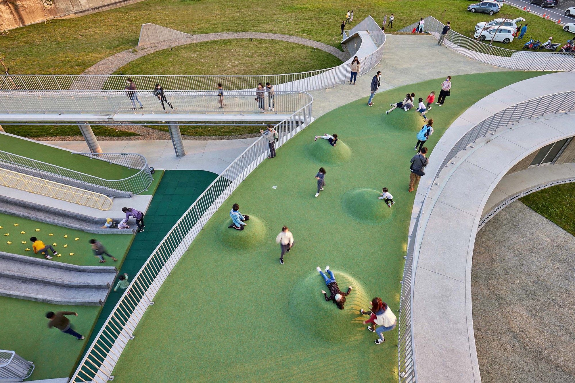 綠色小山丘鋪面採用PU材質，兒童可以盡情嬉戲 新竹那魯灣文化聚落／境衍設計 + 林柏陽建築師事務所
