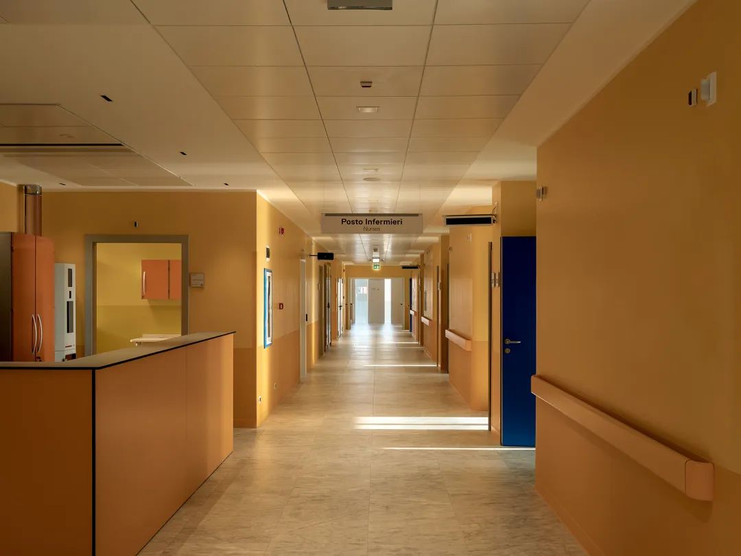 走廊是以橘色為主的暖色系，搭配藍色，顯現義大利設計的特殊魅力 義大利米蘭聖拉斐爾醫院新外科和急診中心 San Raffaele Hospital Ospedale San Raffaele Milano Milan／Mario Cucinella Architects