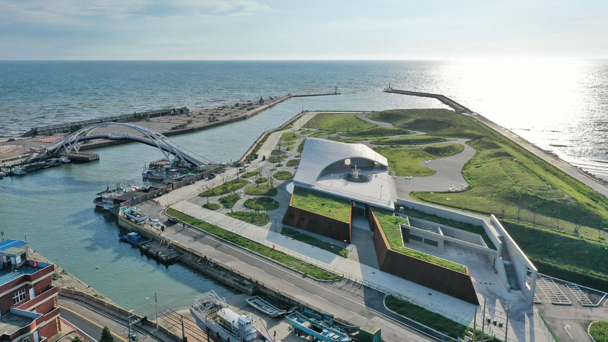 基地位於永安漁港內的永安海螺體驗園區,旁邊是戴小芹建築師設計的海螺館