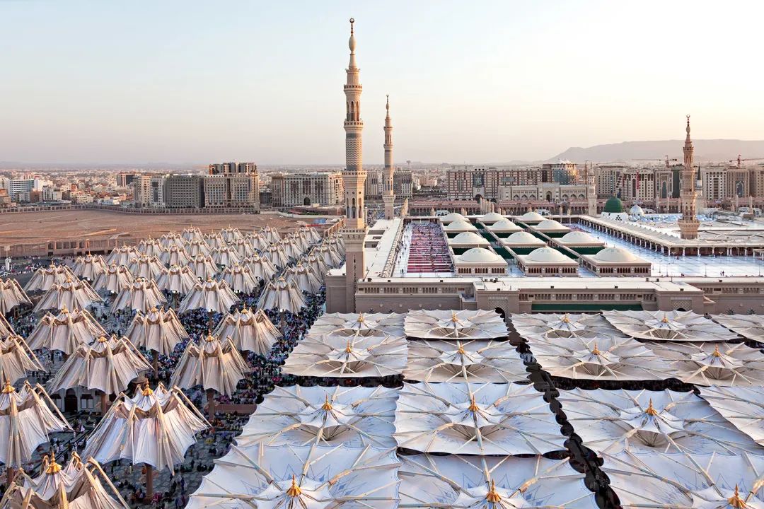 每年,數以百萬計的朝聖者湧向麥地那先知寺(Masjidal-Madinah,伊斯蘭第二大聖寺,又稱麥地那清真寺),來此祈禱和朝拜。過去幾年,朝聖的時間都是在較涼爽的秋季和冬季。但是根據當地的太陽曆,朝聖的時間將再次輪轉到炎熱的夏季。因此,先知寺急需建造遮陽設施,來為朝聖者們提供遮蔽。因此使用PTFE織物,設計了250座巨型遮陽傘,以為清真寺附近的廣場提供陰影。