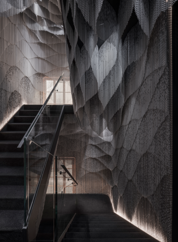 2021年隈研吾改造的西班牙巴特尤公寓（Casa Batllo），裝飾了中庭和一座新樓梯，連接一樓與在地下室的前煤倉展覽空間，以鋁鏈製作了網狀窗簾