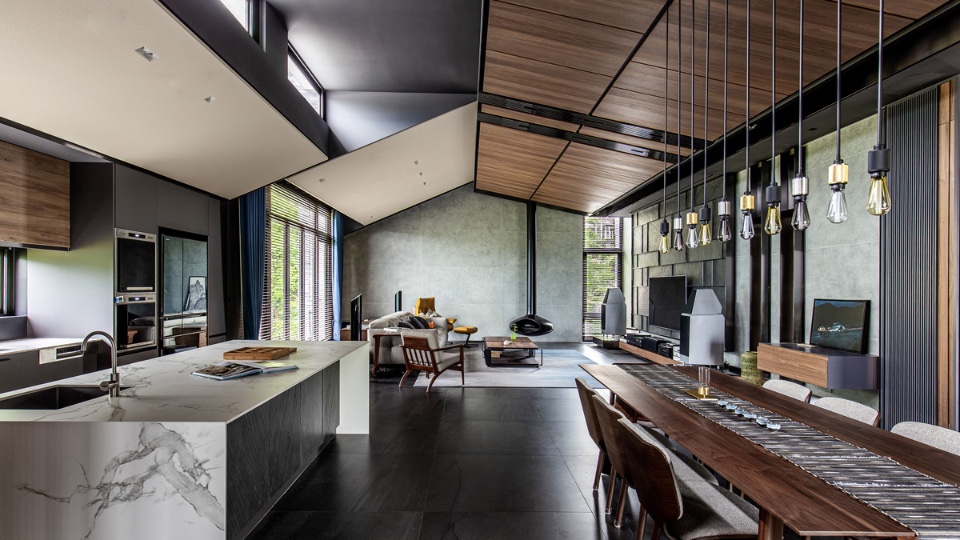 山合院起居空間內，4.2M挑高，胡世昭建築師讓平屋頂下也有斜天花，人字形柚木皮斜天花板留著一排長高窗，增進空氣的對流