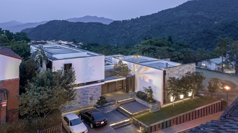 臨路側鳥瞰，量體高低與進退演繹著後方山際的變化，基地位居台北盆地東南邊的秀岡山莊，居住環境幽靜安寧，因地處盆地上緣氣流較易流通，又與廣闊的山脈相鄰，空氣清新無比，豐富的生態伴隨蟲鳴鳥叫，地衣散布在基地內的原石上，海拔480公尺，氣溫比台北市區涼快約2度，景觀與周遭環境完全符合業主李銘煌的期待