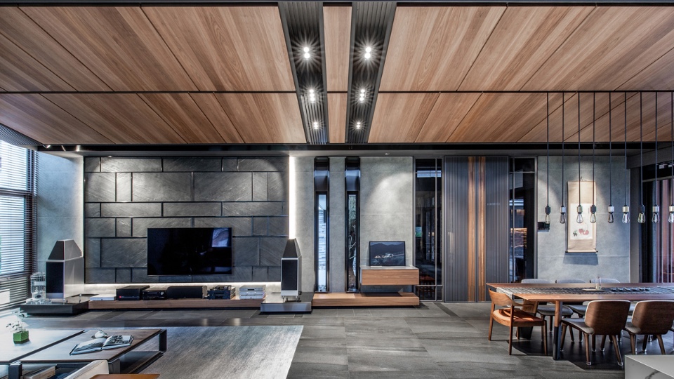 起居間：斜向木天花下的長向主牆面，開敞的空間以自然媒材鋪敘舒心氛圍