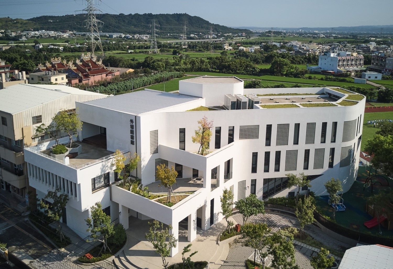 蔡顯恭建築師特別採用垂直分割錯落設計,「外埔圖書館」呼應外埔的田園印象,並透過2、3樓整面玻璃幃幕,可眺望遠方的鐵砧山及火炎山,內部空間則透過1至3樓的書牆圍塑,如同書卷展開,讓室內的光透出於書卷上,傳達出「書中自有黃金屋」的概念