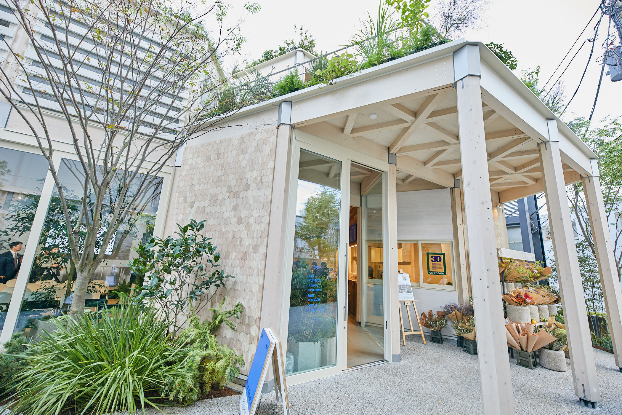 入口處是 CIRTY FLOWERS 鮮花店，主要出售羅斯鮮花，裡面是 CIRTY CAFE，一家使用回收食品的咖啡館。 菜單上的蔬菜和水果都是在用咖啡館的食物殘渣（zanzas）和非標準化產品施肥的土壤中種植的。 該設施還擁有一個植物工廠和一個屋頂花園，在那裡種植的草藥也得到了利用（Photo: Kisa Toyoshima）