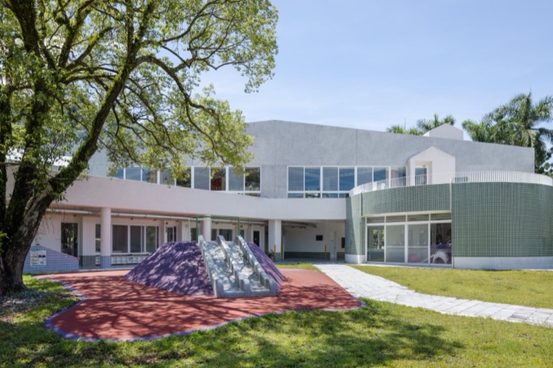 嘉義縣大埔國中小附設幼兒園 究境聯合建築師事務所二樓量體的半圓和一樓的戶外遊戲空間共同形成了一個圓，而入口也有一個圓形的室內遊戲空間，這些量體關係讓兩個不同的機能互相成為了一個整體（攝影：趙宇晨）