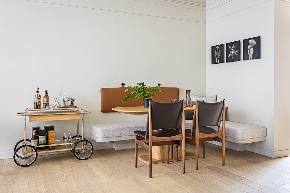 舒適的餐廳區，牆上選掛攝影大師林炳存的作品，三小幅花卉組排，與餐桌上的豐美相互呼應；House of Finn Juhl的「埃及椅」則為餐食空間增添溫潤、內斂氛圍。（相片提供：義泰建設）