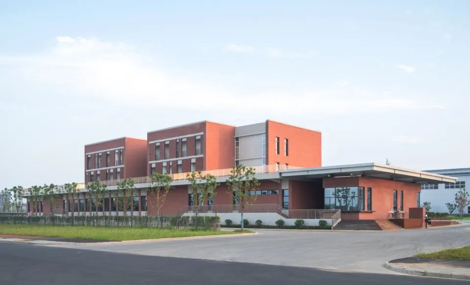 從主入口望向門衛室及員工樓 勤美達精密機械項目 / 潘冀聯合建築師事務所