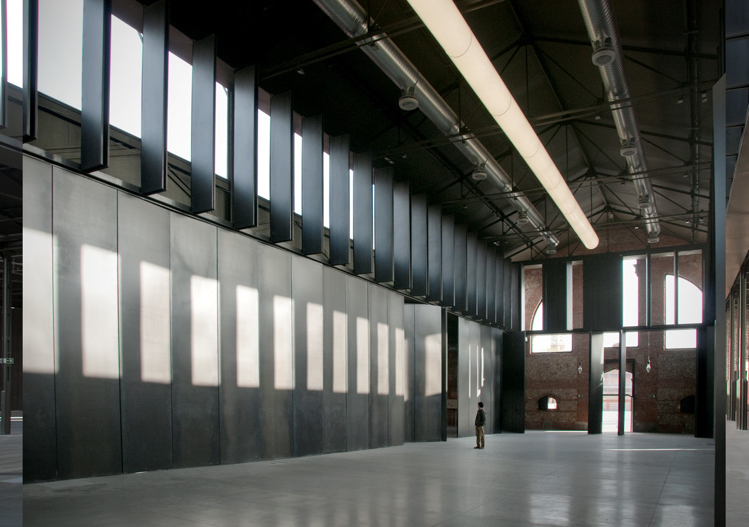 馬德里Naves Matadero文化中心引入了雙層挑高的設計，周圍環繞著大片鋼板門，這種設計與屠宰場保留下來的質樸磚牆形成鮮明對比