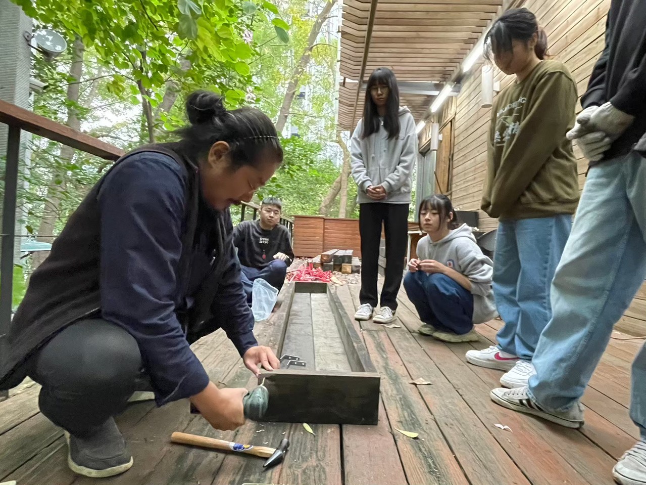 林清俊老師(左)帶領建築系同學運用廢棄木棧板製作植栽盒。 北科大/提供