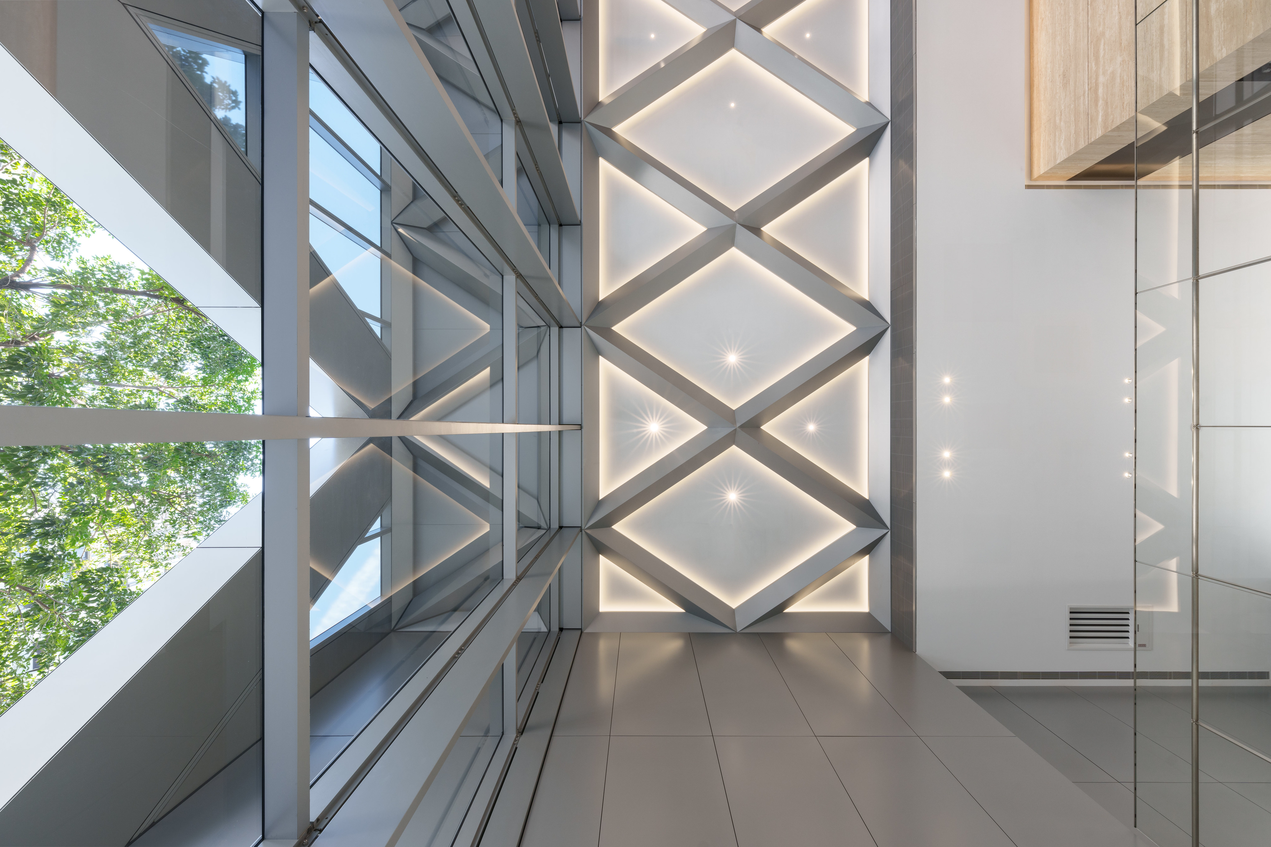 鑽石斜交的圖騰語彙自建築立面延伸入室內天花。攝影：YHLAA