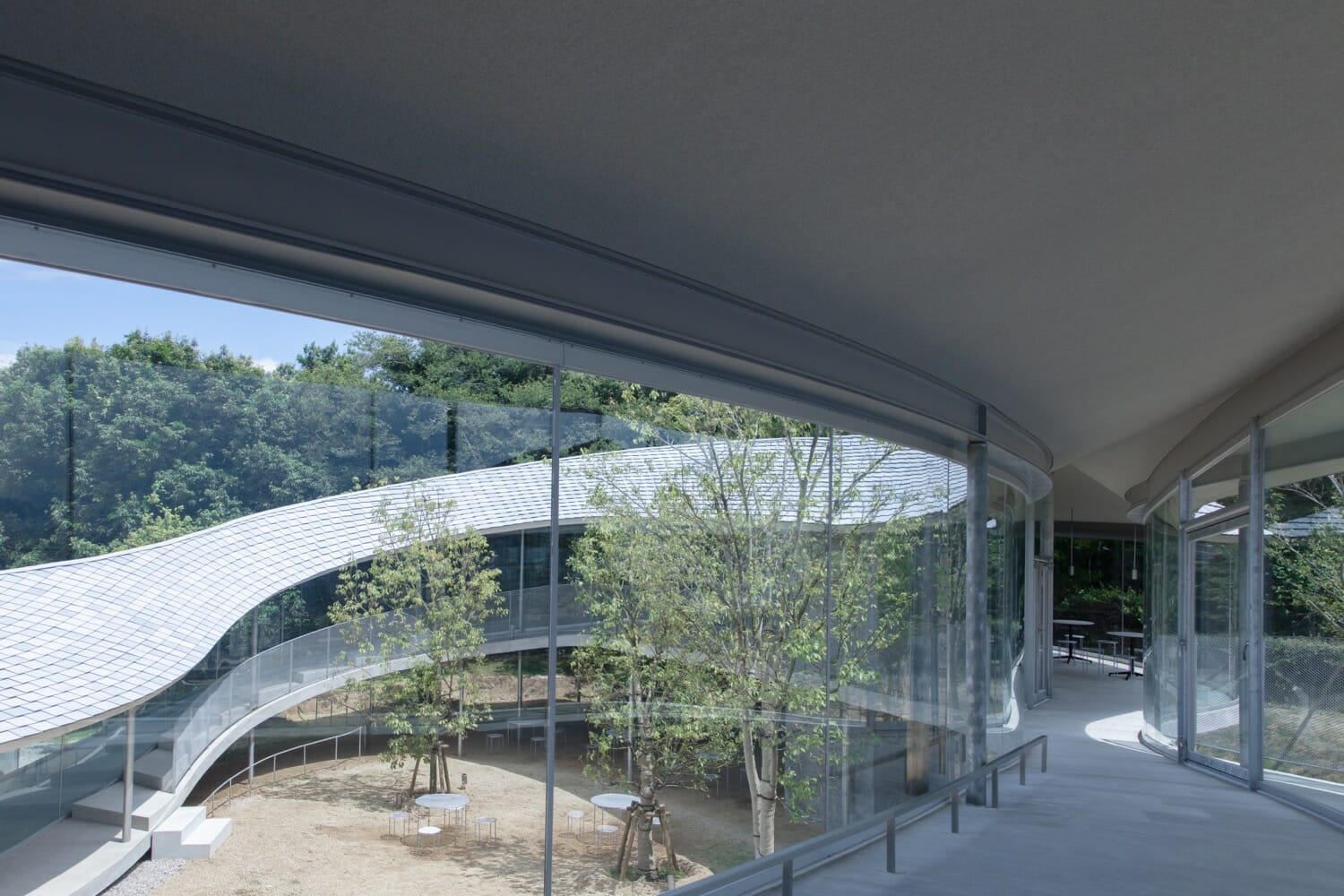 周防貴之帶領設計團隊探索地形與建築有機結合的方式，使高松市屋島山上交流拠点施設「やしまーる」結構體如同基地的一部分，呼應地形，自然融入環境中