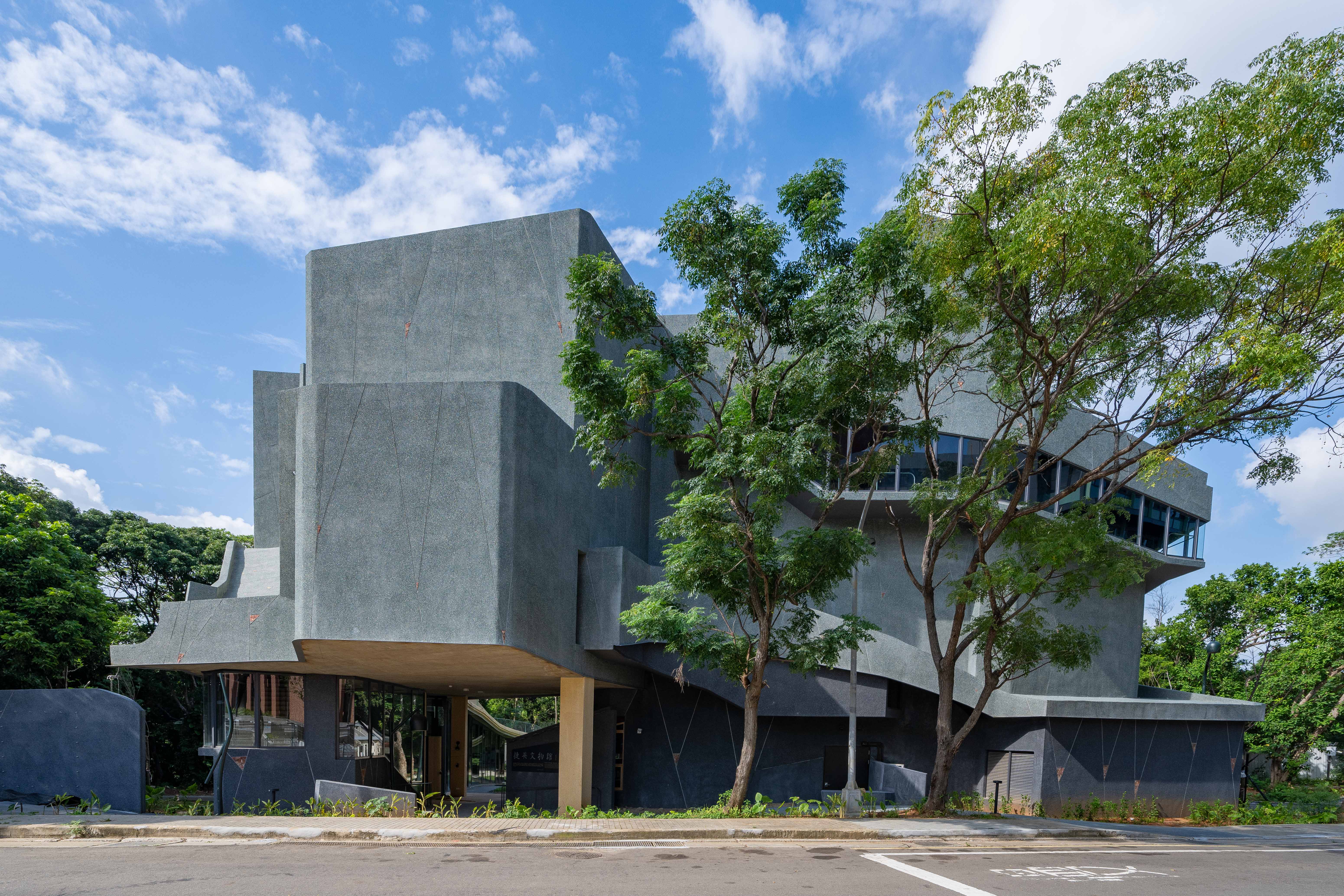 國立清華大學「捷英文物館」今天落成,將典藏哲學所特聘講座教授、中研院院士楊儒賓夫妻捐贈的近4000件東亞近代文物。圖/清大提供 建築師黃聲遠以「多元歷史視角及溫柔對待環境的建築」理念來設計這座隱身林間的「捷英文物館」。這裡原來有一處圍繞在果樹林間的農家老三合院。為最大程度保留原貌,黃聲遠把文物館蓋成了ㄇ形,讓老三合院成為新三合院東廂的一部分,蓮霧、芒果、龍眼樹仍在館舍間茂密生長,結實纍纍