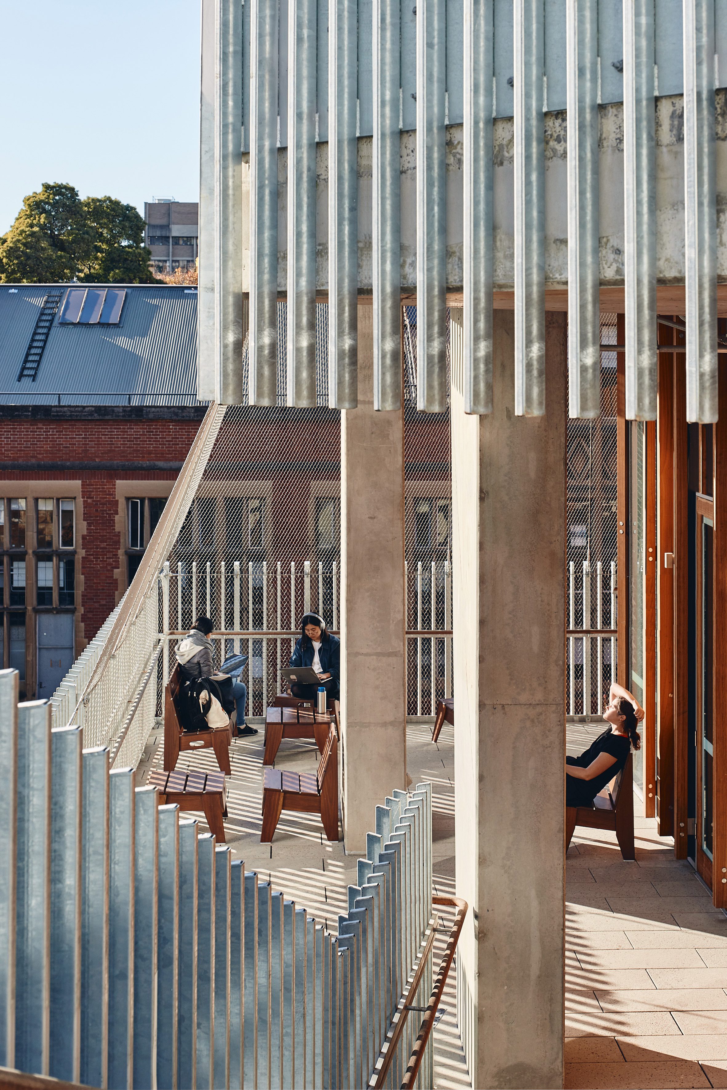 University of Melbourne Student Pavilion by KoningEizenberg 澳洲墨爾本大學 學生活動中心 清水模 清水混凝土 學生的社交互動是該建築設計的核心目標之一。設計師將建築物的主要流線推向外部，透過大面積的陽台和露天樓梯，營造出開放而非正式的社交空間。這些空間不僅提供了學生在課間放鬆、互動的場所，還讓學生可以在學習和休閒之間自由切換