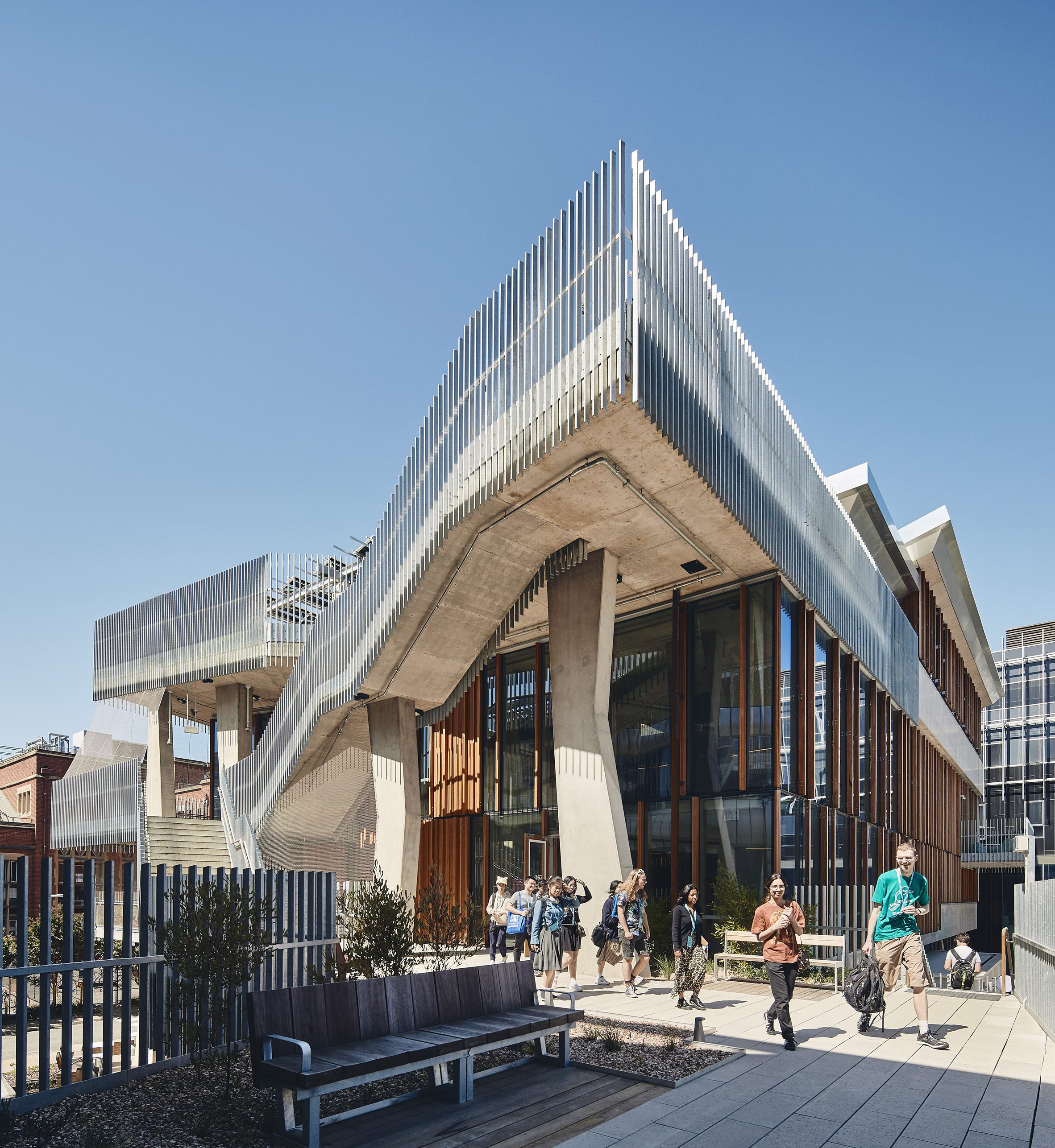 University of Melbourne Student Pavilion by KoningEizenberg 澳洲墨爾本大學 學生活動中心 清水模 清水混凝土 設計和規劃由多家建築事務所共同完成，其中包括澳洲本土的Lyons、NMBW Architecture Studio、Greenaway Architects等。這些建築團隊經由學校舉辦的設計競賽獲得了該項目，並在合作中共同推動整體規劃的完成