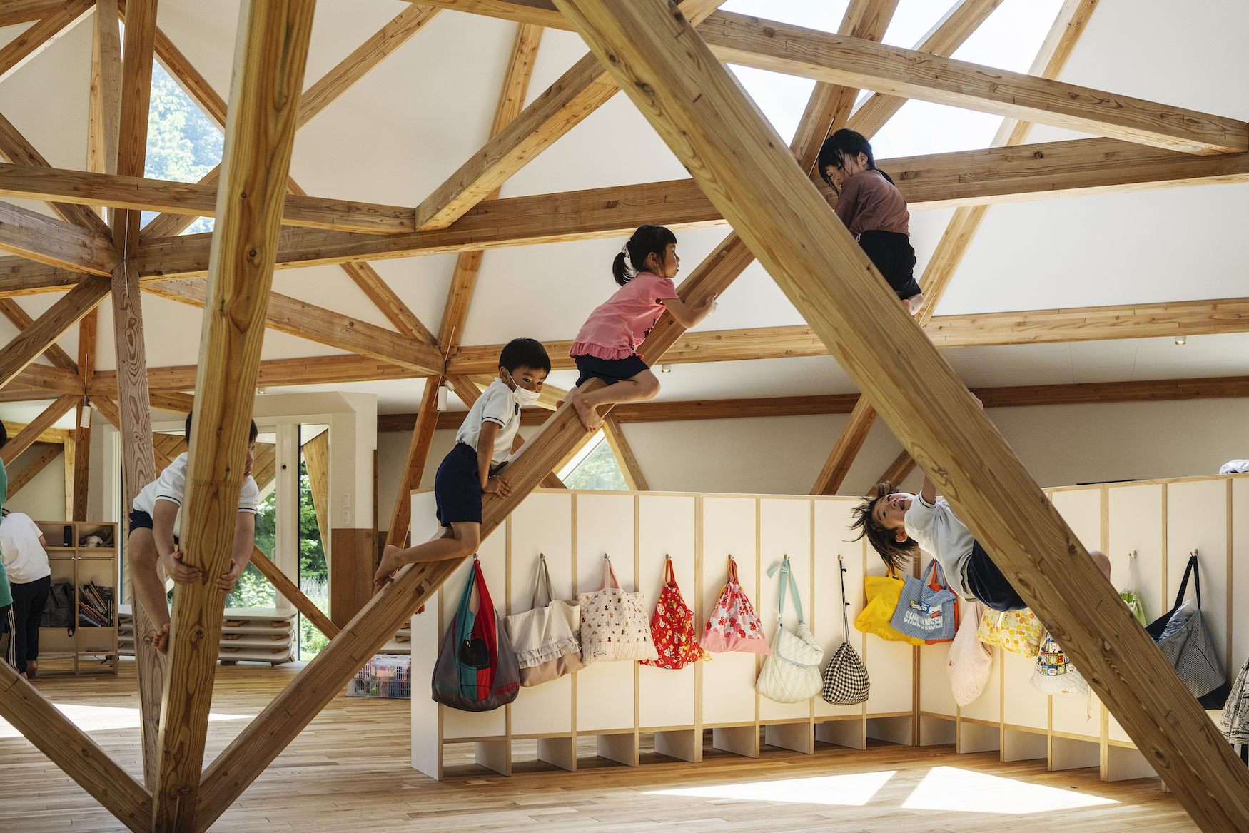 北海道木構木造幼兒園浦河之友森林幼兒園(浦河フレンド森のようちえん)Urakawa Friend Mori Noyochien 照井康穗建築師事務所(YASUO TERUI Architects)立體桁架結構不僅是這座幼兒園的設計亮點,更成為孩子們的遊戲夥伴。孩子們爬上木構結構,體驗空間的多樣性與互動性,從中激發想像力與冒險精神。在光線灑落的室內,溫潤的木材質感帶來自然的舒適氛圍,每個細節都展現出設計的巧思與人性化考量