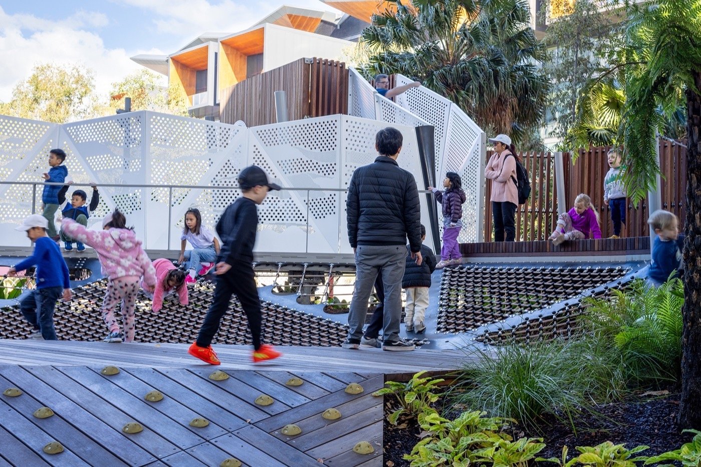 Darling Harbour Playground 雪梨達令港兒童遊戲場 溜滑梯 景觀設計 Aspect Studios 多功能的遊玩設施,包括攀爬結構、傾斜平台和網狀地面,鼓勵孩子們自由發揮想像力並增進肢體協調。結合植栽和現代設計,這裡成為都市與自然交融的完美場域,深受各年齡層家庭的喜愛