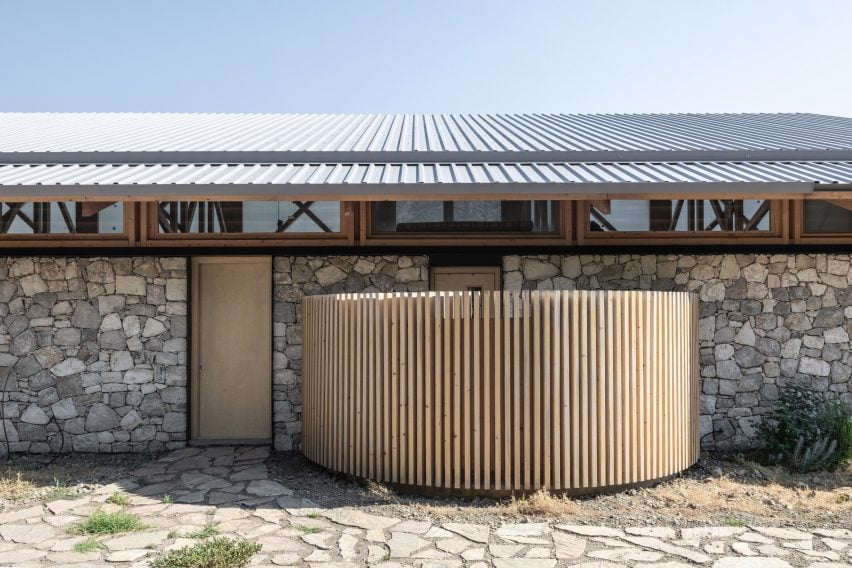 Exterior of stone house with open-air bath 設計團隊將南側立面設計得相對較小，以減少夏季吸收的熱量，而北側立面則保持高達4.5米，最大限度地將自然光和景色引入室內。朝南的傾斜屋頂適合安裝太陽能板並用於收集雨水，充分體現了功能性與環保性的結合