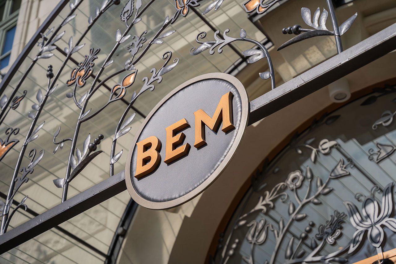 戶外金屬標牌,上面用粗體字寫著「BEM」,周圍是華麗的花卉設計。