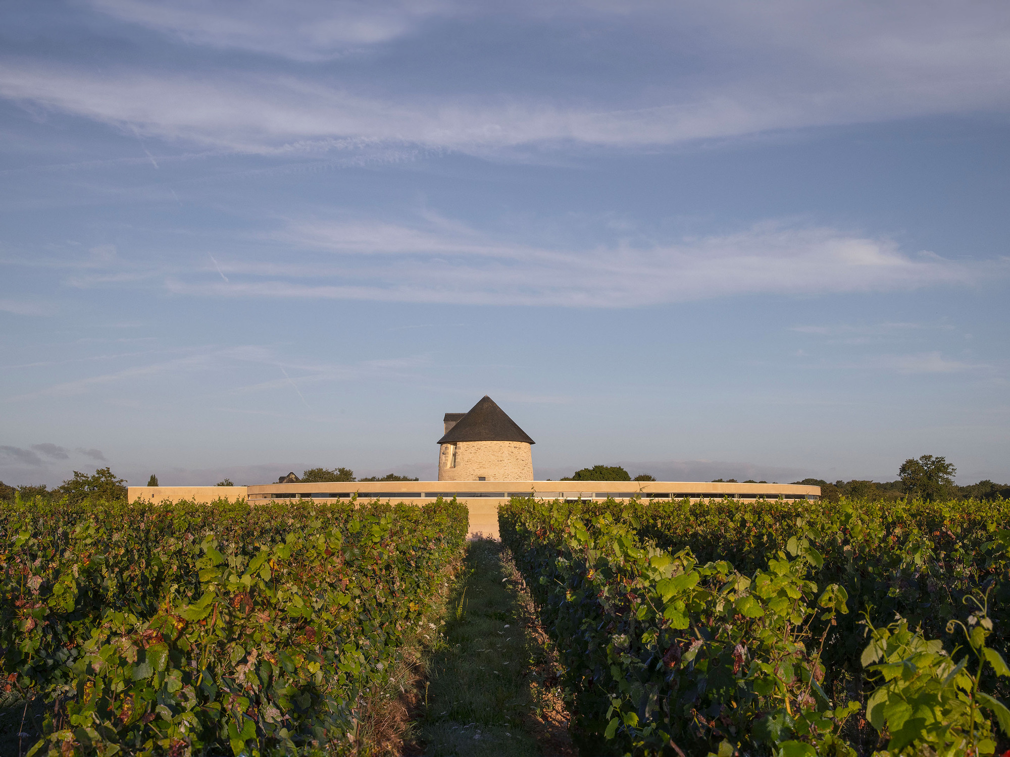 Wine Storehouse 酒莊與磨坊共同構成了一個視覺與文化的焦點。磨坊簡約的石造結構，穩穩屹立於中央，周圍的酒莊建築低調延展，展現對當地自然與歷史的敬意
