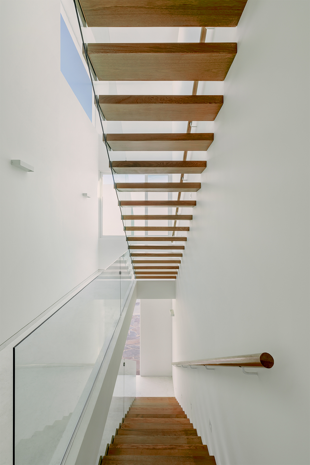 墨西哥住宅 Natura House Cotaparedes Arquitectos 樓梯以深色木質踏板構成，加上玻璃欄杆，讓樓梯看起來輕盈而通透