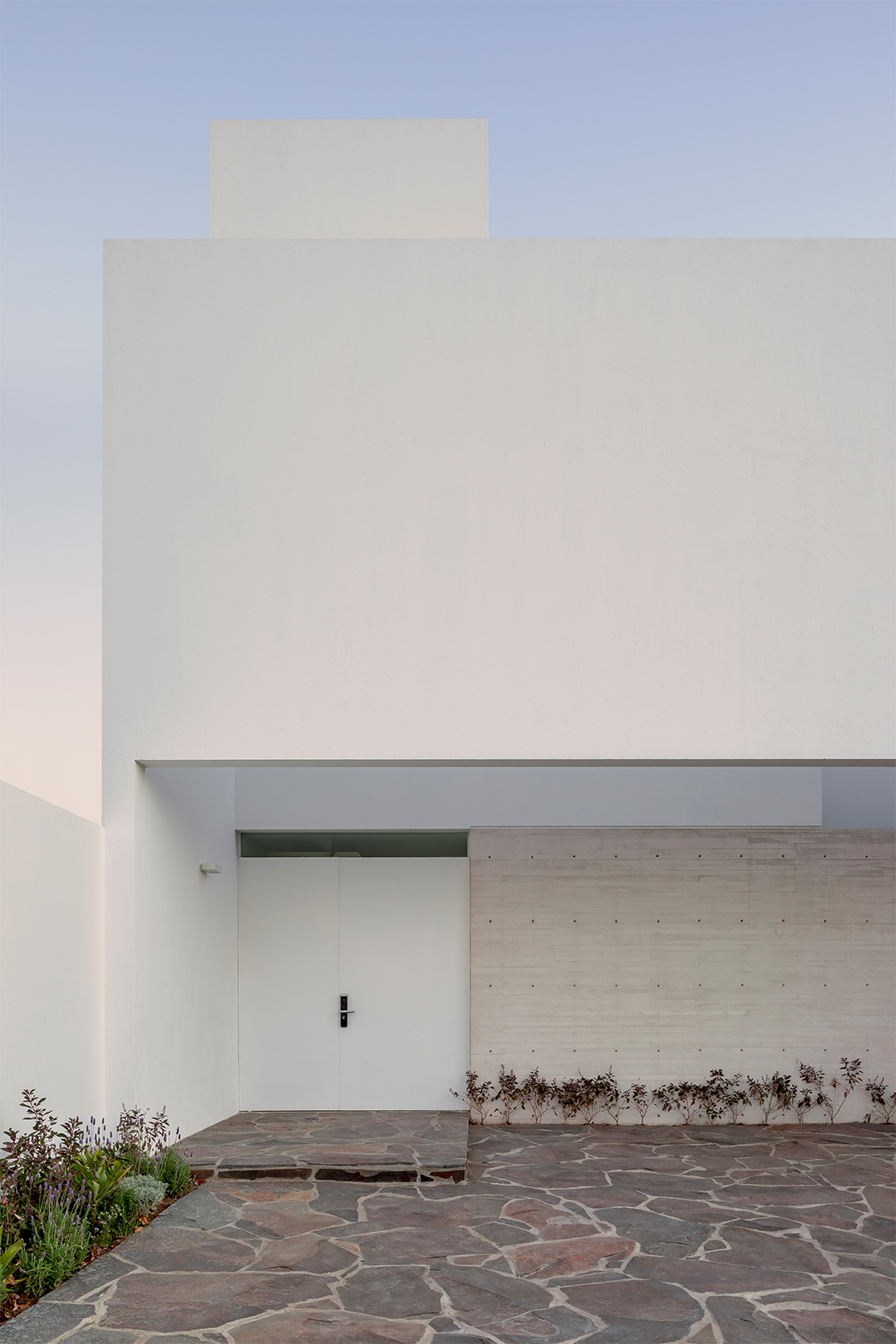 墨西哥住宅 Natura House Cotaparedes Arquitectos「Natura House」住宅以白色外牆為主,搭配簡約的材料,並利用懸臂牆巧妙地遮擋陽光,同時兼顧隱私。住宅的地下室設有開放式廚房、客廳及餐廳,並延伸至戶外庭院,創造出寬敞舒適的空間