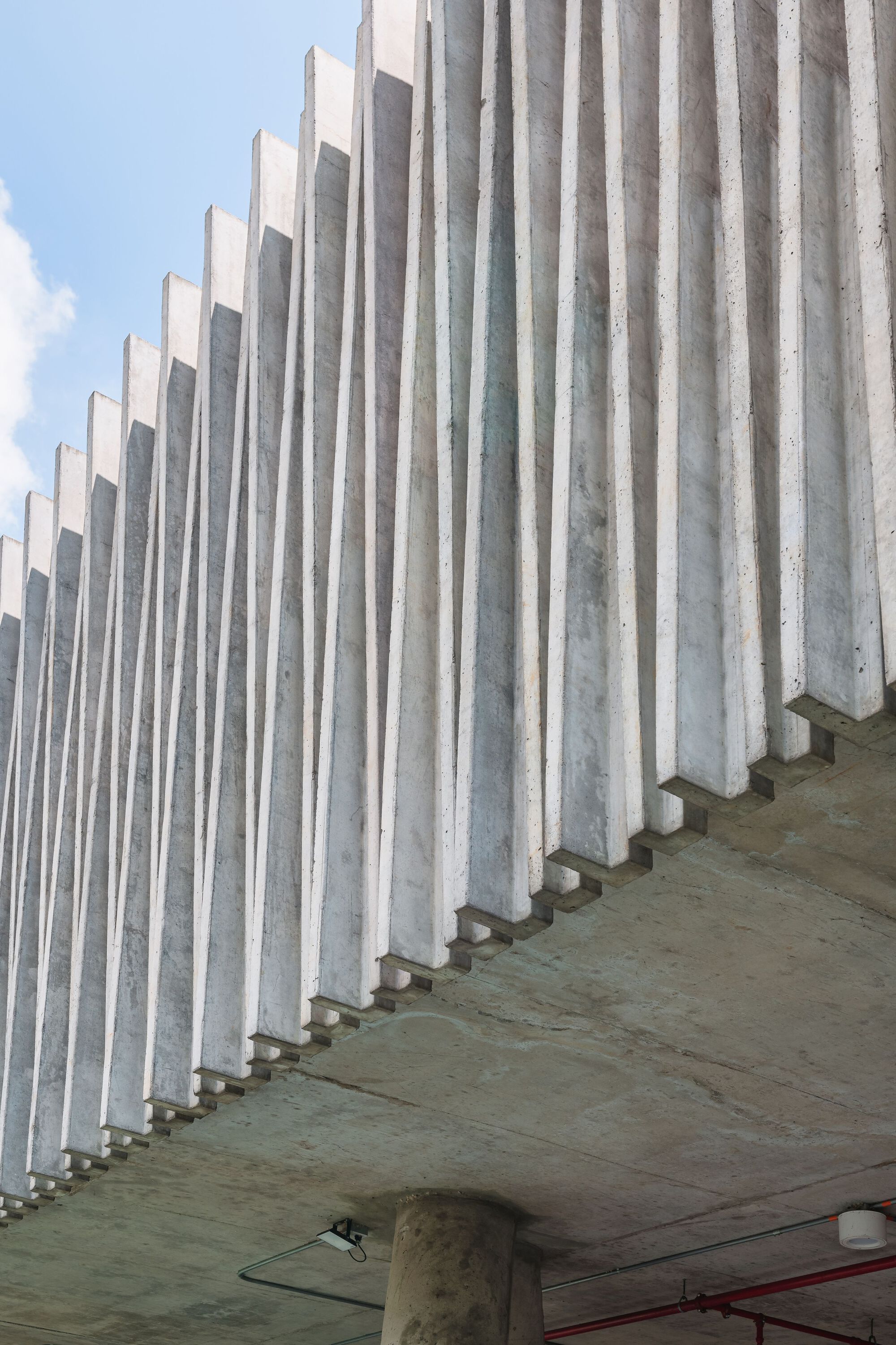 設計師巧妙地運用預鑄混凝土構件，在外立面設置垂直格柵窗，可以阻擋陽光，萬一街上發生槍戰時，還能作為阻擋流彈的擋箭牌，保護孩子們的安全