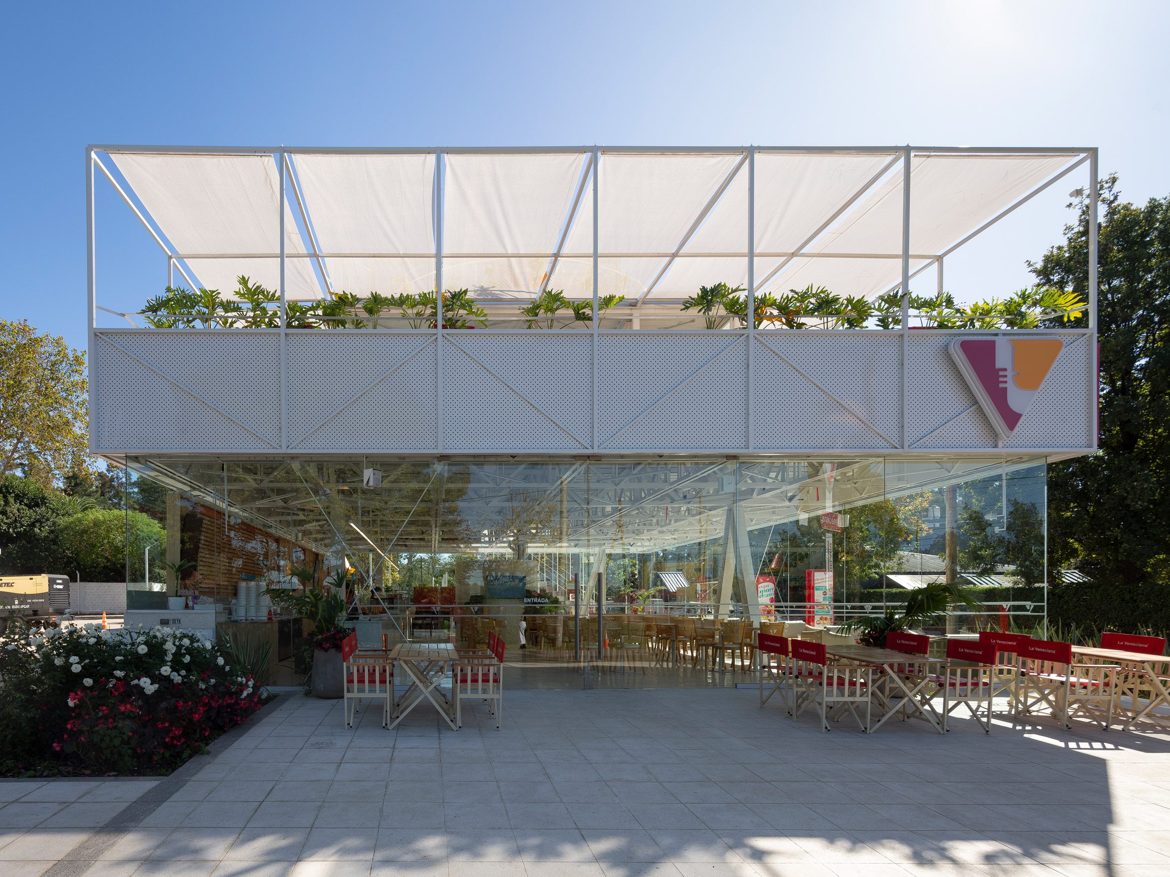 阿根廷 Veneciana Canning ICE CREAM 冰淇淋店 DRM Arquitectura 位於布宜諾斯艾利斯郊區的Veneciana Canning冰淇淋店,結構設計強調輕盈感,抬高的建築量體由倒V形鋼柱與簡潔圓柱支撐,地面空間則採用通透設計,提供半戶外休憩場域