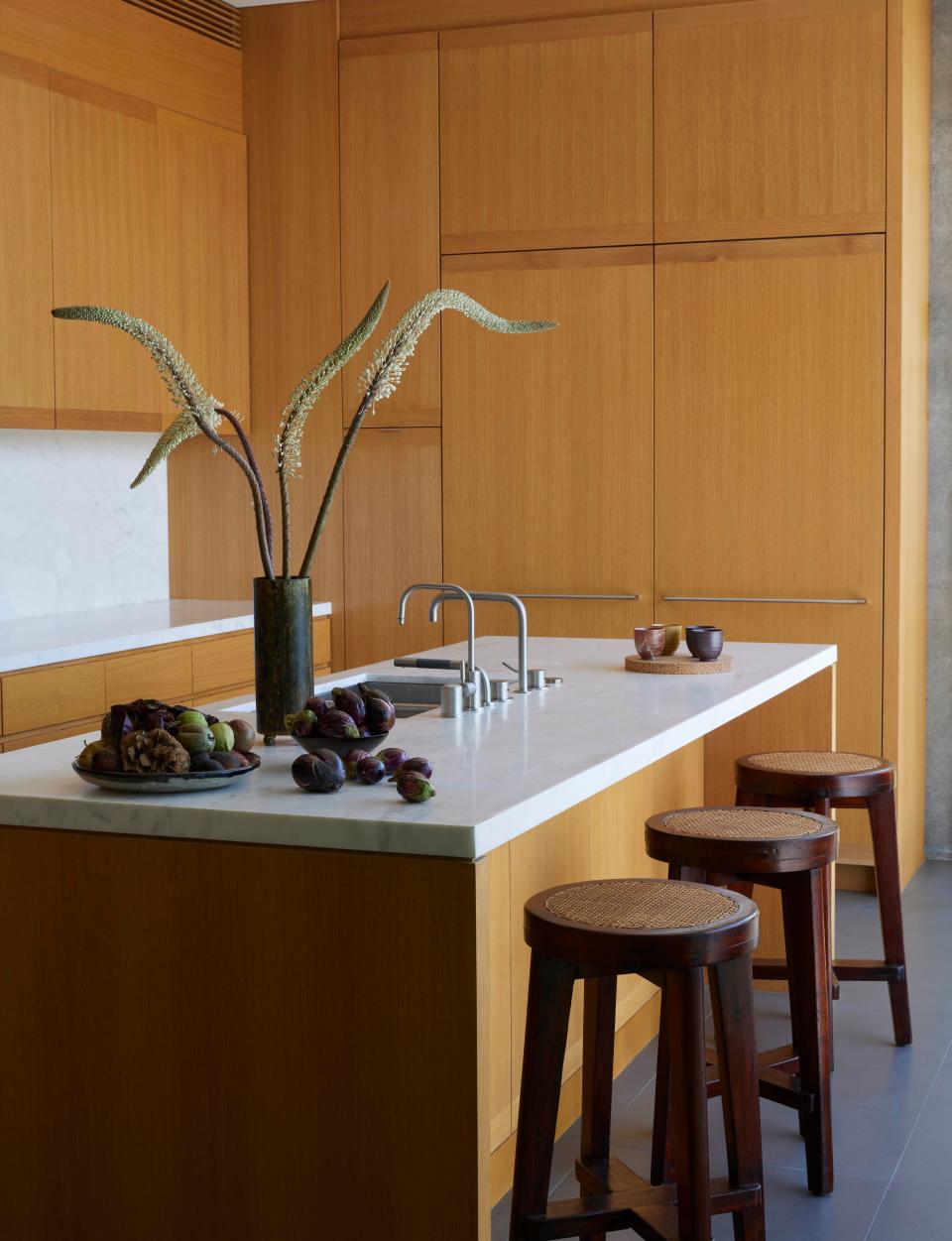 Pierre Jeanneret 的凳子靠在廚房中島旁