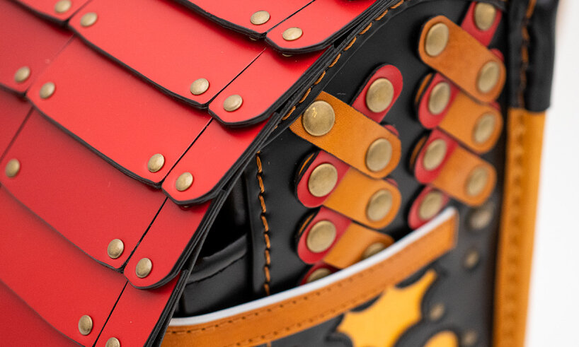 這款盔甲風後背包（Samurai Armor Randoseru Backpack）也運用了「黃銅」（おうどう）與「鋲」（びょう）等日本傳統盔甲中常見的元素。「黃銅」在此指的是黃銅材質，與黃金價錢相近，在古代日本是種貴重金屬，廣泛應用於製作武器與盔甲。而「鋲」則是指金屬的鉚釘或扣件